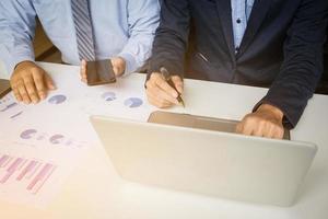 conceito de reunião de equipe de análise de marketing. tripulação de jovem empresário trabalhando com novo projeto de inicialização no estúdio moderno e notebook na mesa de madeira. foto