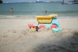 brinquedos de plástico multicoloridos em uma grande praia de areia do mar foto