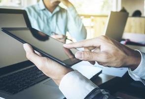 processo de trabalho em equipe de negócios, mãos de empresários apontando para tablet e documento durante a explicação dos novos dados do projeto do plano na reunião. foto