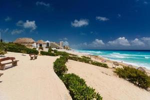 praia de areia com água azul em um dia ensolarado perto de cancun, méxico foto