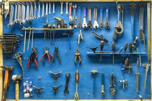 conjunto de ferramentas de reparo em uma oficina moderna de bicicletas e carros em um fundo azul foto