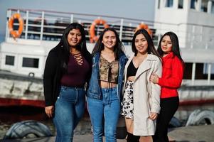 grupo de quatro meninas latinas felizes e bonitas do Equador posou contra o barco. foto