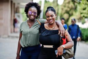 duas garotas afro-americanas andando e posando na rua da cidade. foto