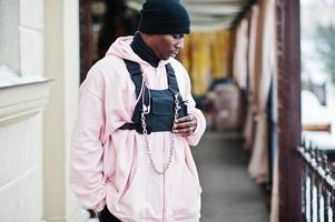 homem afro-americano de estilo urbano elegante com capuz rosa posou. foto