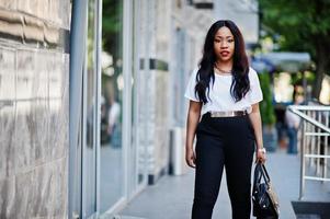 mulher de negócios americano africano elegante com bolsa nas ruas da cidade. foto