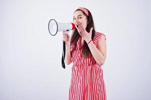 retrato de uma jovem mulher bonita de vestido vermelho falando no megafone. foto