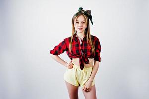 jovem dona de casa engraçada na camisa quadriculada e short amarelo pin up estilo isolado no fundo branco. foto