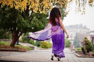 menina hindu indiana no saree violeta tradicional posou na rua de outono. foto