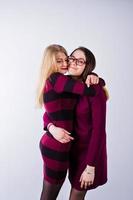 retrato de duas amigas em vestidos de cereja posando no estúdio. foto