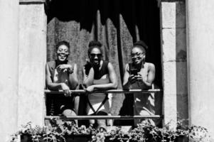 três elegantes mulheres afro-americanas posaram no dia ensolarado de verão ao ar livre. foto