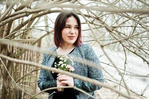 retrato de menina morena de vestido preto em madeira de primavera. foto