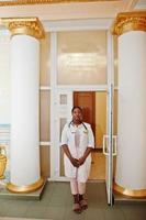 estudante de médico americano africano fêmea no jaleco com estetoscópio dentro da universidade médica. foto