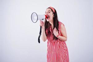 retrato de uma jovem mulher bonita de vestido vermelho falando no megafone. foto