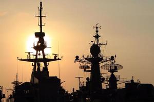 navio de guerra com pôr do sol atrás foto