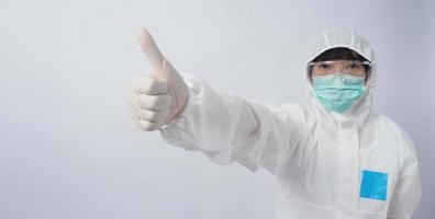 médico em gesto de terno de ppe faz sinal de mão. representam a vitória sobre o vírus. foto