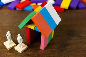 a casa de construção multicolor do domino na imagem da mesa de madeira. foto