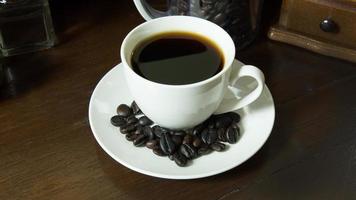 xícara de café e grãos de café no fundo da imagem vintage de madeira. foto