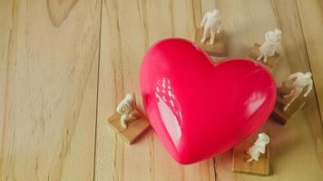 coração rosa e figura branca na mesa de madeira para saúde, conteúdo médico. foto