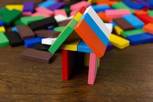 a casa de construção multicolor do domino na imagem da mesa de madeira. foto