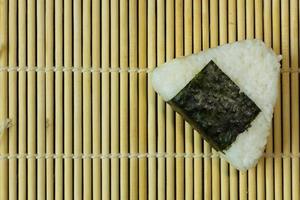 a comida japonesa onigiri arroz branco formado em formas triangulares ou cilíndricas e muitas vezes envolto em nori. foto