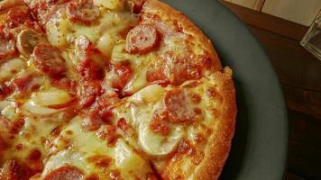 pizza em chapa preta na mesa de madeira para conteúdo alimentar. foto