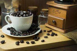 o humor vintage de grãos de café e tom na mesa de madeira foto