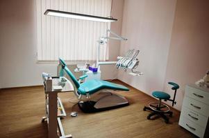 cadeira odontológica por dentistas em azul com luz médica. prática odontológica moderna. foto