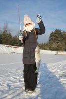 jovem feliz em roupas quentes detém uma truta pega em uma ponta. pesca de inverno. foto