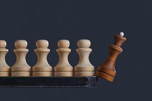 peões brancos deslocam o rei preto. peças de xadrez. o conceito de um no campo não é um guerreiro. foto