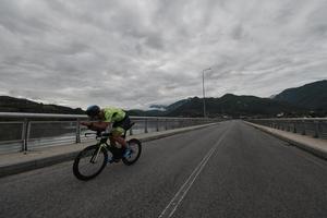 atleta de triatlo andando de bicicleta no treinamento matinal foto