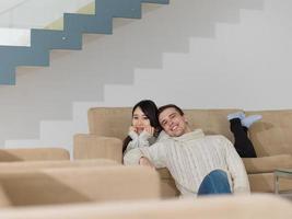 feliz casal multiétnico relaxando em casa foto