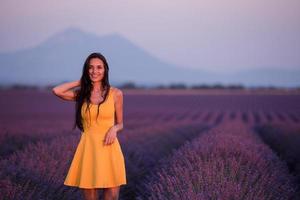 mulher de vestido amarelo no campo de lavanda foto