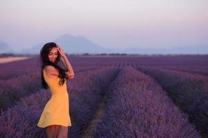 mulher de vestido amarelo no campo de lavanda foto