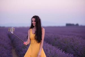 mulher no campo de lavanda tirando selfie foto