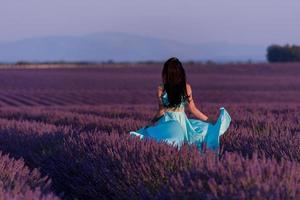 mulher no campo de flores de lavanda foto