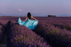 mulher no campo de flores de lavanda foto