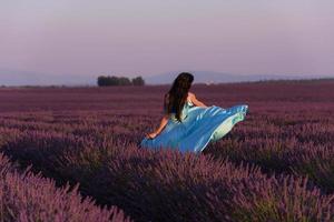 mulher no campo de flores de lavanda foto