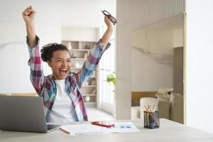 muito feliz estudante afro-americana adolescente recebeu e-mail com boas notas nos exames, comemora o sucesso foto