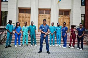grupo de estudantes de medicina africanos posou ao ar livre contra a porta da universidade. foto