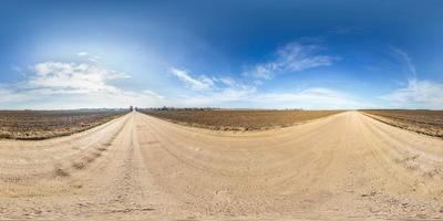 panorama hdri esférico completo sem costura visão de ângulo de 360 graus na estrada de cascalho entre campos na primavera com nuvens impressionantes em projeção equirretangular, pronto para conteúdo de realidade virtual vr ar foto