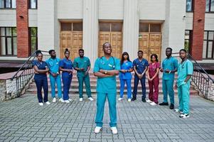 grupo de estudantes de medicina africanos posou ao ar livre contra a porta da universidade. foto