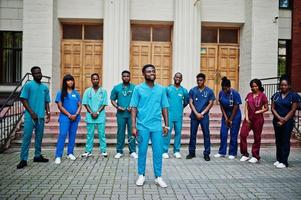 grupo de estudantes de medicina africanos posou ao ar livre contra a porta da universidade. foto