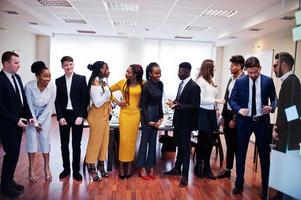 grande grupo de onze empresários multirraciais em pé no escritório. grupo diversificado de funcionários em trajes formais. foto