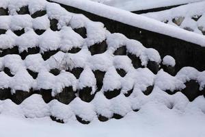 parede de pedra coberta de neve eu foto