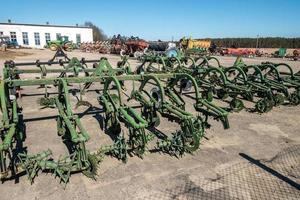 estacionamento de máquinas agrícolas e colheita. fileiras de arados, cultivadores, corpos foto