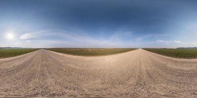 panorama hdri esférico sem costura completo vista de ângulo de 360 graus na estrada de cascalho entre campos na primavera com céu claro em projeção equirretangular, pronto para conteúdo de realidade virtual vr ar foto