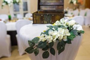lindas flores na mesa de jantar elegante no dia do casamento. decorações servidas na mesa festiva em fundo desfocado foto
