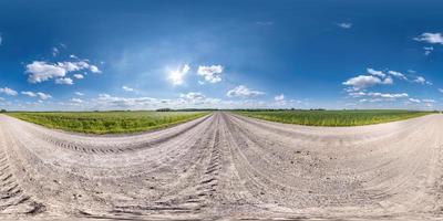 panorama hdri sem costura esférico completo vista de ângulo de 360 graus em estrada de cascalho de areia branca sem tráfego entre campos com céu claro em projeção equirretangular, conteúdo vr ar foto