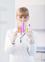 pesquisador feminino segurando um tubo de ensaio em laboratório foto