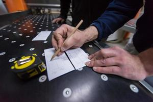 carpinteiros calculando e programando uma máquina de trabalhar madeira cnc foto